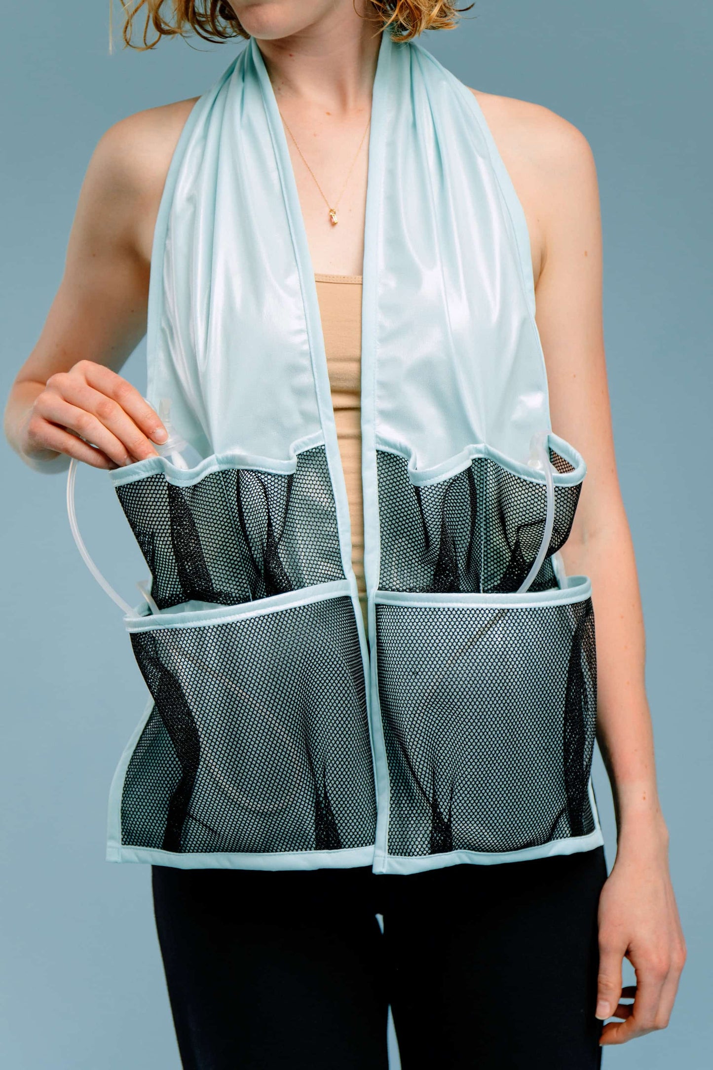 Person wearing a waterproof scarf with mesh pockets containing post-surgery drains and tubes.