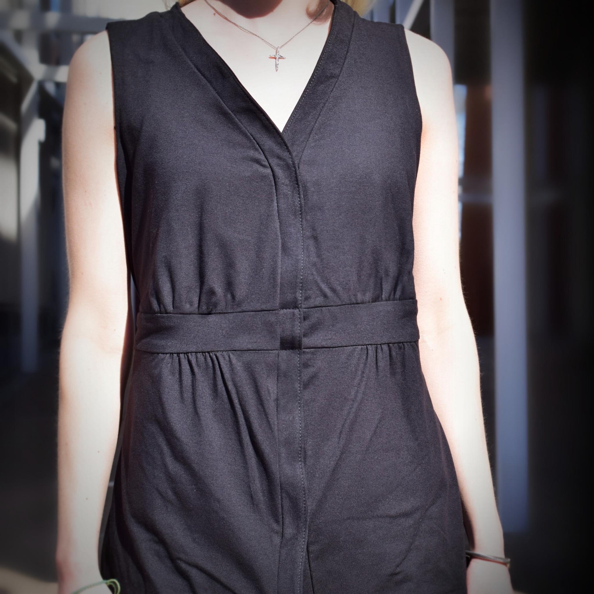 Body of woman wearing a sleeveless black mastectomy top.