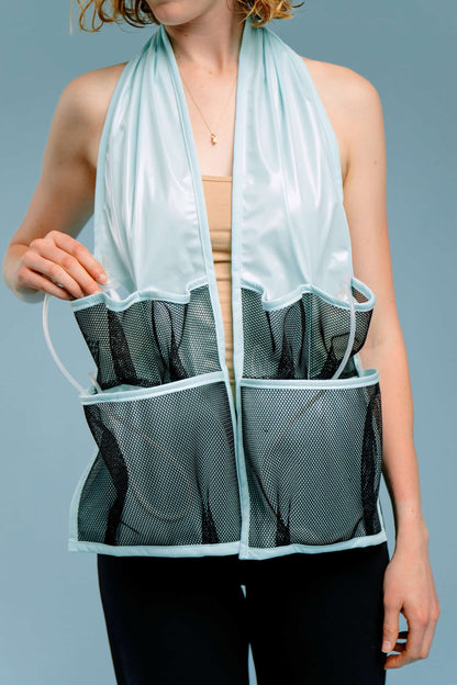 Person wearing a waterproof scarf with mesh pockets containing post-surgery drains and tubes.