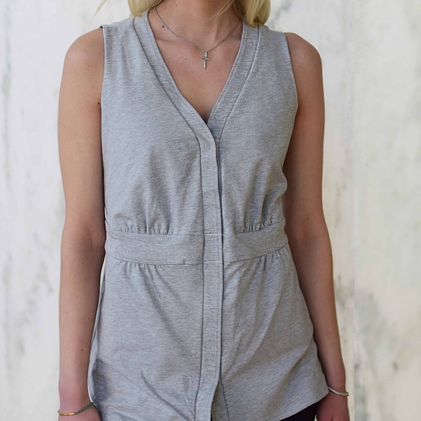 Grey sleeveless breast cancer shirt with a v-neckline and fashionable silhouette.