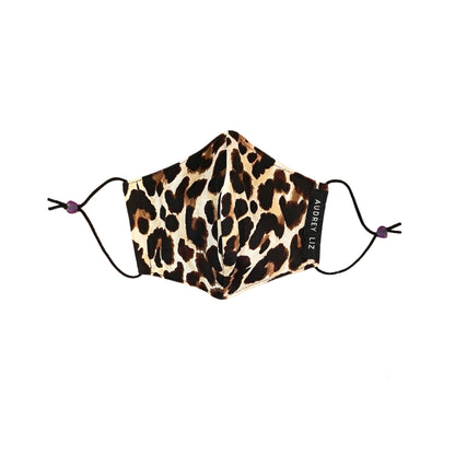Folded women’s facial mask in a traditional leopard print fabric.