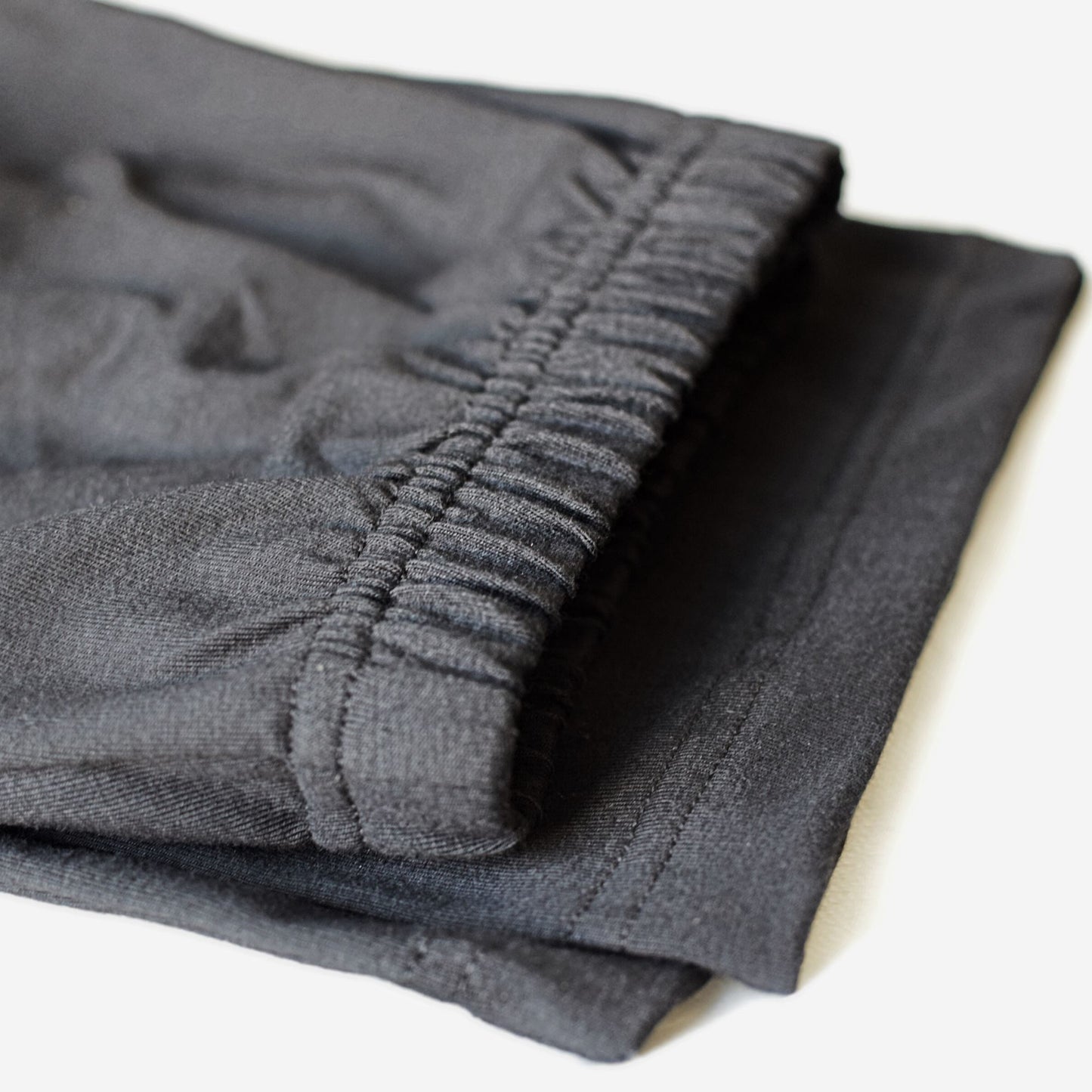Folded straight leg cotton pants with non-roll elastic waist.
